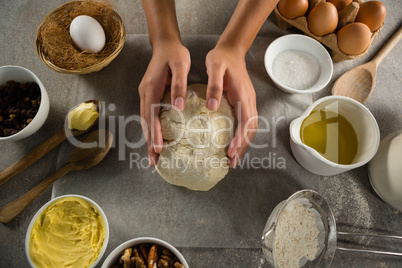 Woman preparing dough surrounded with various ingredients