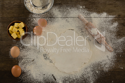 Flattened dough sprinkled with flour on a wooden table