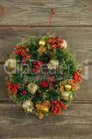 Christmas wreath hanging on wooden background