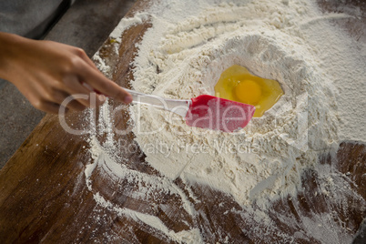 Woman mixing flour and egg with a batter spatula