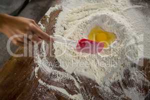 Woman mixing flour and egg with a batter spatula