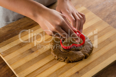 Man molding gingerbread dough on wooden board