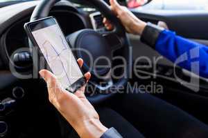 Cropped image of woman using smartphone during test drive