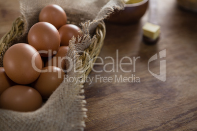 Brown eggs in wicker basket on a wooden table