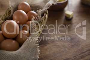 Brown eggs in wicker basket on a wooden table
