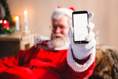 Santa claus sitting and showing his smartphone