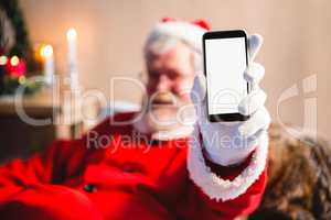 Santa claus sitting and showing his smartphone