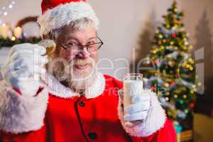 Santa Claus having a cookie with milk