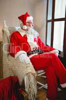 Thoughtful santa claus looking through window in living room