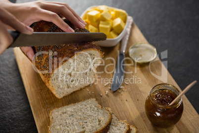 Woman cutting freshly baked multigrain bread