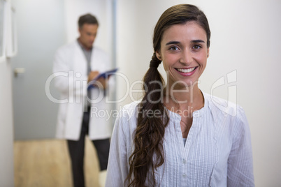 Smiling woman against dentist standing in lobby