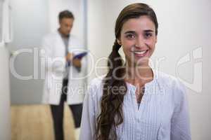 Smiling woman against dentist standing in lobby
