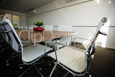 Empty chairs by conference table at office