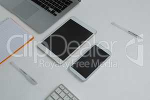 Various electronic gadgets and book on white background