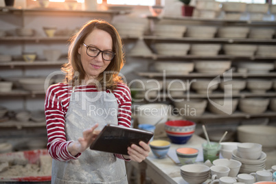 Female potter using digital tablet