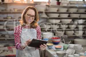 Female potter using digital tablet