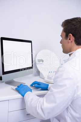 Side view of dentist working on computer