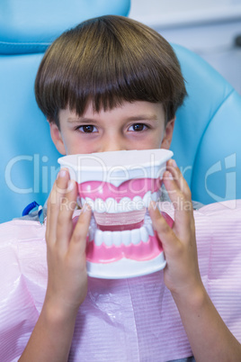 Portrait of boy covering face with dental mould