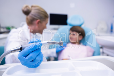 Close up of dentist holding medical equipment while examining boy