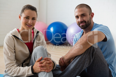 Portrait of student and instructor relaxing in yoga studio