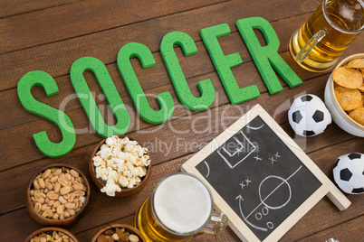 Strategy board, snacks and football on wooden table