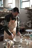 Male potter working at worktop