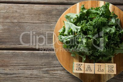 Fresh kale leaves with text blocks on cutting board