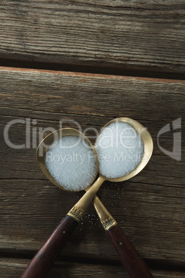 Salt in spoon on wooden table