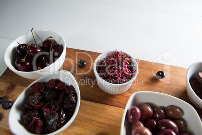 Close-up of olives with various fruits in bowl on cutting board