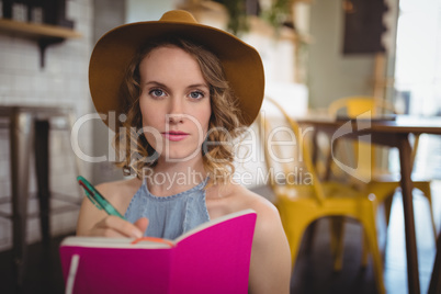 Portrait of confident young woman holding pink dairy