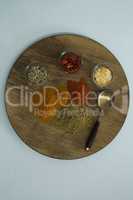 Various spices on wooden board with spoon