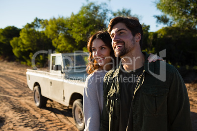 Happy couple by vehicle on field