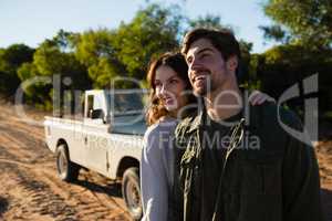 Happy couple by vehicle on field