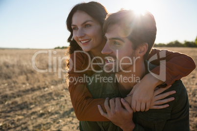 Man giving woman piggyback ride on landscape