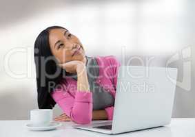 Businesswoman at desk with laptop with bright background