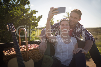 Couple taking selfie with mobile phone in a car