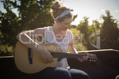 Woman playing guitar in a car Woman playing guitar in a car