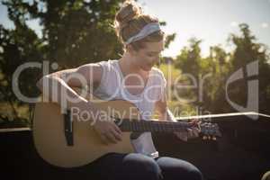 Woman playing guitar in a car