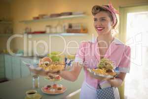 Waitress holding plate of meals in restaurant