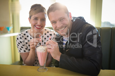 Couple having milkshake in restaurant