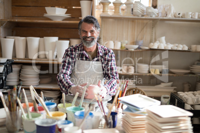 Portrait of male potter holding bowl