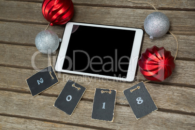 Baubles and cards forming 2018 around the digital tablet