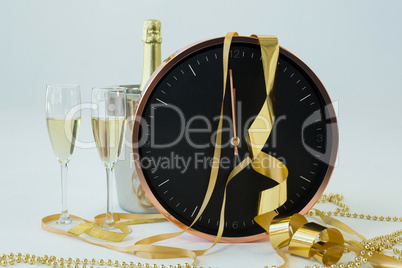 Champagne with clock and glass on white background