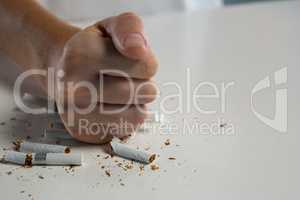 Woman breaking cigarette with fist