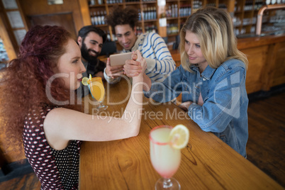 Women arm wrestling and men capturing a shoot