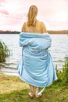 Young woman with bathrobe at the lake