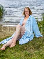 Young woman with bathrobe at the lake