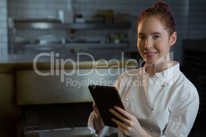 Female chef using digital tablet in the kitchen