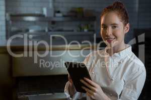 Female chef using digital tablet in the kitchen