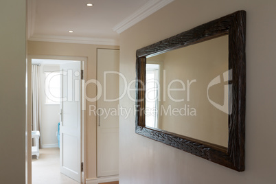 Wooden framed mirror on white wall